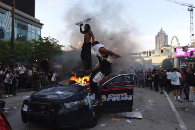 Protesters smash police cars in Atlanta. Picture: AP