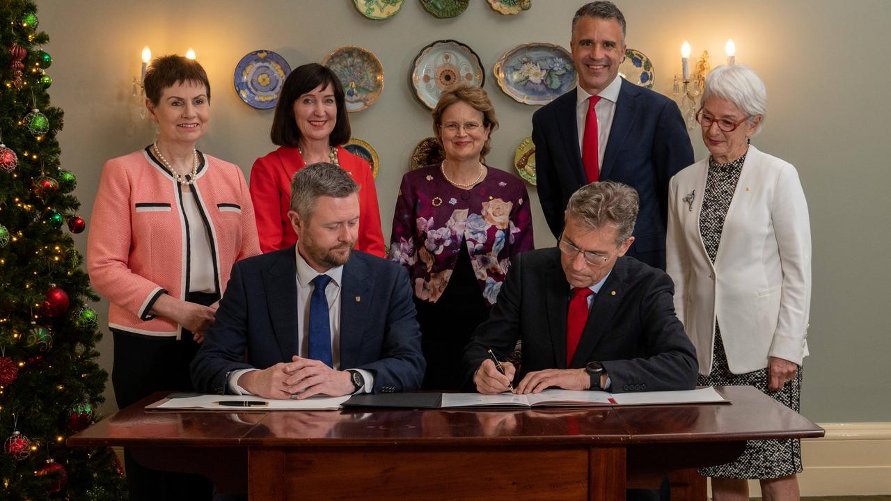 Inking a university merger agreement on December 6, 2022 are UniSA chancellor Pauline Carr, Deputy Premier Susan Close, Governor Frances Adamson, Premier Peter Malinauskas, University of Adelaide chancellor Catherine Branson (l-r front) UniSA vice-chancellor David Lloyd and University of Adelaide vice-chancellor Peter Hoj. Picture: Naomi Jellicoe