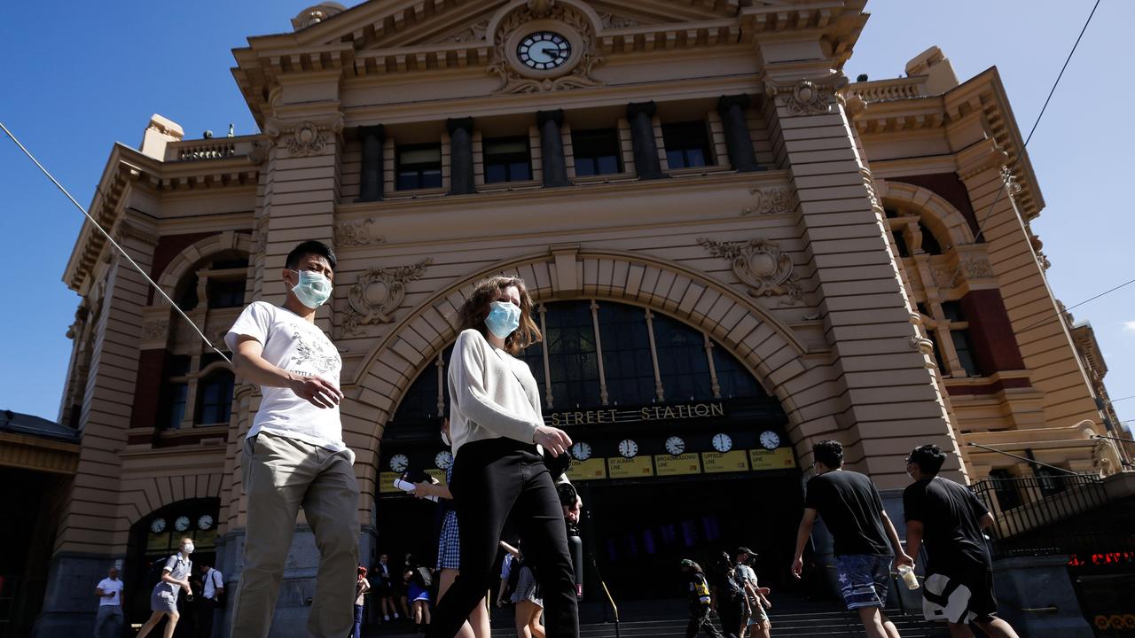 People cross a street in Melbourne on February 12, 2021, after authorities ordered a five-day statewide lockdown Photo by Con Chronis / AFP