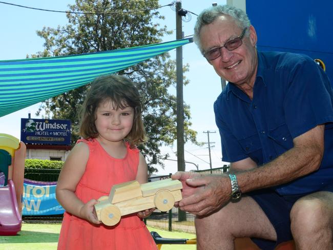 Madison Maris is handed a wooden car toy from Leith Tebbit. Photo Will Hunter / Dalby Herald