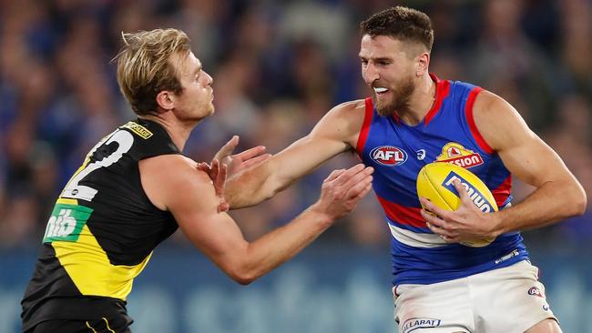 MELBOURNE, AUSTRALIA - APRIL 30: Marcus Bontempelli of the Bulldogs fends off David Astbury of the Tigers during the 2021 AFL Round 07 match between the Richmond Tigers and the Western Bulldogs at the Melbourne Cricket Ground on April 30, 2021 in Melbourne, Australia. (Photo by Michael Willson/AFL Photos via Getty Images)