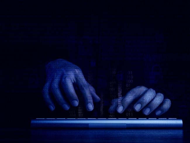 Cyberattack and internet crime, hacking and malware concepts. Digital binary code data numbers and secure lock icons on hacker' hands working with keyboard computer on dark blue tone background. Picture: iStock