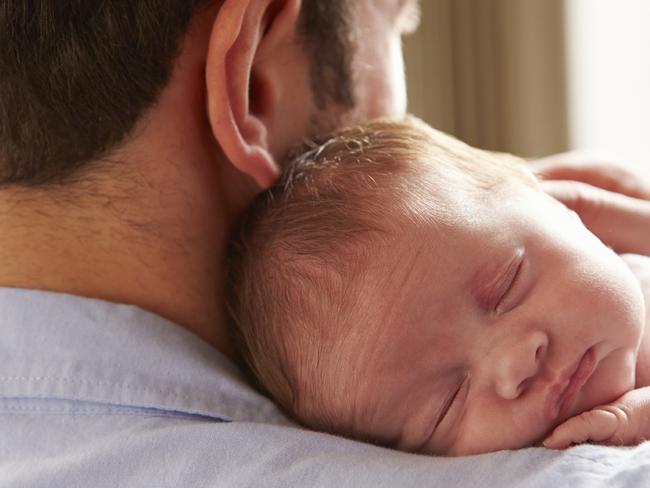 Father At Home With Sleeping Newborn Baby Daughter