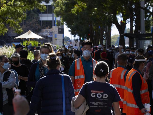 SYDNEY, AUSTRALIA - JULY 15: People queue up at the New South Wales Health mass vaccination hub in Homebush on July 15, 2021 in Sydney, Australia. Lockdown restrictions have been extended for at least a further two weeks as NSW continues to record new community COVID-19 cases. Residents of Greater Sydney, the Blue Mountains, the Central Coast and Wollongong are subject to stay-at-home orders with people are only permitted to leave their homes for essential reasons. Essential reasons include purchasing essential goods, accessing or providing care or healthcare, essential work, education or exercise. Exercise is restricted to within the local government area and no further than 10km from home and with a maximum of two people per group. Browsing in shops is prohibited and only one person per household can leave home for shopping per day. Outdoor public gatherings are limited to two people, while funerals are limited to 10 people only. The restrictions are expected to remain in place until 11:59pm on Friday 30 July. (Photo by Brook Mitchell/Getty Images)