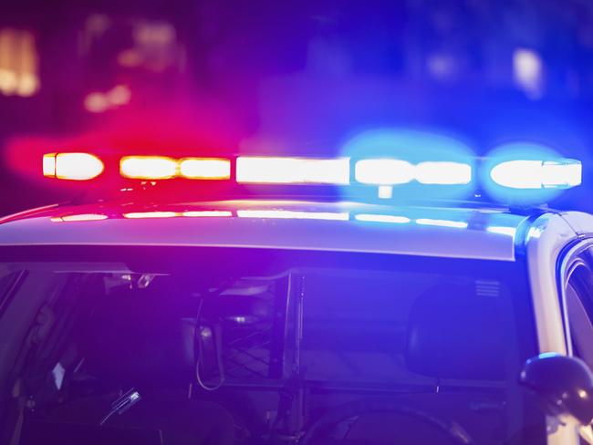 The roof of a police patrol car at night, with the blue and red lights flashing.