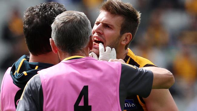 Grant Birchall gets checked out by Hawthorn medical staff. Picture: Michael Klein