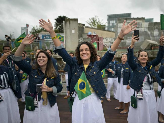 Members from Brazil's delegation greet other boats as they sail along the river Seine. Picture: AFP