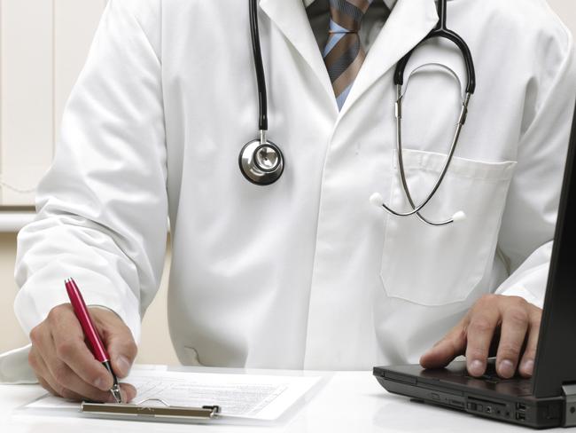 Doctor writing patient notes on a medical examination form or prescription