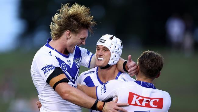 SYDNEY, AUSTRALIA - FEBRUARY 15: Blake Wilson of the Bulldogs celebrates scoring a try with team mates Jacob Preston and Blake Taaffe of the Bulldogs during the NRL Pre-season challenge match between Canterbury Bulldogs and Melbourne Storm at Belmore Sports Ground on February 15, 2024 in Sydney, Australia. (Photo by Brendon Thorne/Getty Images)