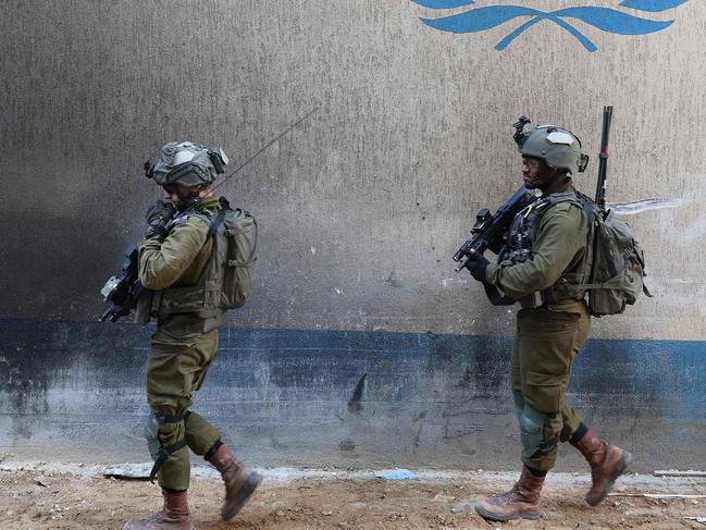 --PHOTO TAKEN DURING A CONTROLLED TOUR AND SUBSEQUENTLY EDITED UNDER THE SUPERVISION OF THE ISRAELI MILITARY-- This picture taken during a media tour organised by the Israeli army on February 8, 2024, shows Israeli soldiers inside a compound of the United Nations Relief and Works Agency for Palestine Refugees (UNRWA) in the Gaza Strip, amid ongoing fighting between Israel and the Palestinian militant group Hamas. (Photo by JACK GUEZ / AFP)