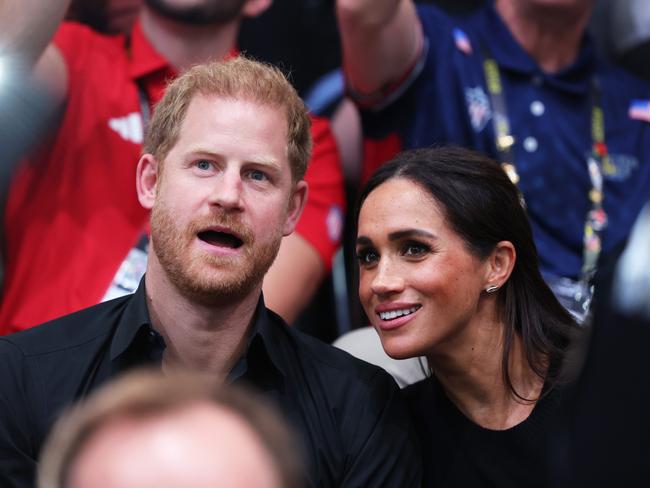 Meghan Markle cuddles up to Prince Harry at the Games. Picture: Getty Images