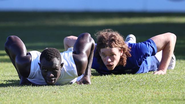 Majak Daw, left, at training last Friday. The North Melbourne defender has been boosted by the news that a muscle tear he suffered in the gym won’t require surgery. Picture: Michael Klein