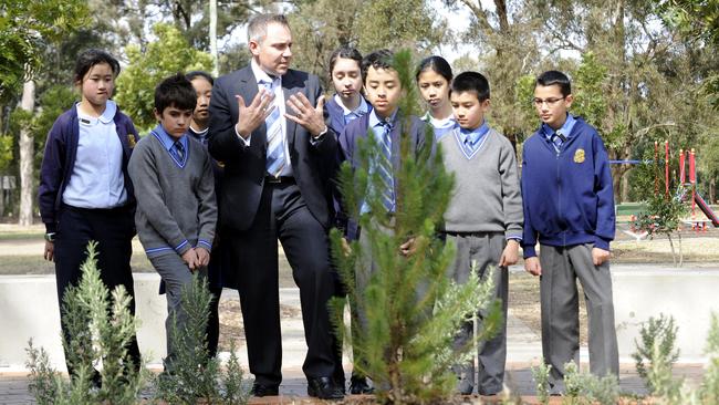 Fairfield Labor MP Guy Zangari with students and the, much larger, sapling when it was planted.