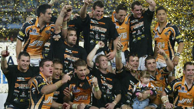 Chris Heighington (front row, second from left) celebrates the 2005 grand final victory with Wests Tigers teammates.