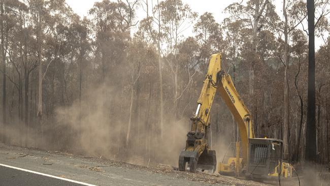 Workers remove trees on the Princes Highway near Mallacoota.