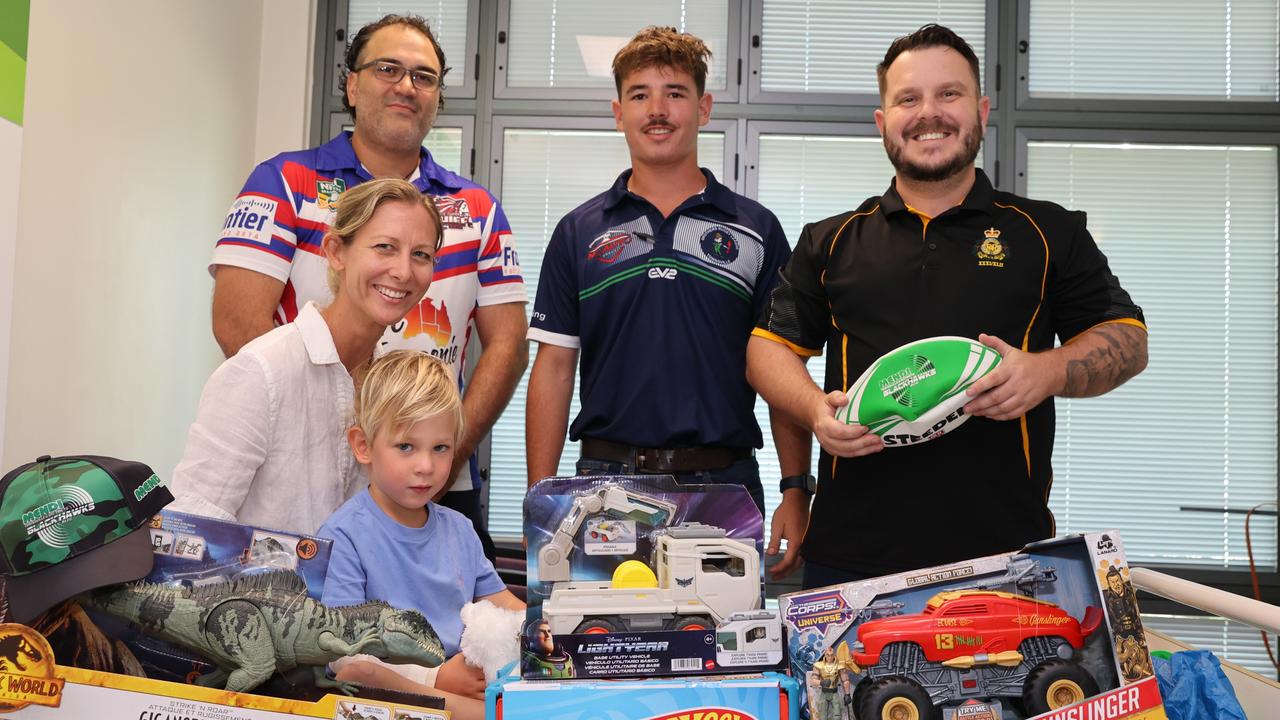 Julia Creek's Lawson White, 3, and his mother Amanda Stevens receives surprise Christmas cheer while they stay at the Townsville University Hospital children's ward. Townsville Chiefs Rugby League member Tane Hutana, Brothers Rugby League member Mitch Doyle, and Herbert MP Phillip Thompson bring presents as part of an annual Christmas visit to the hospital.