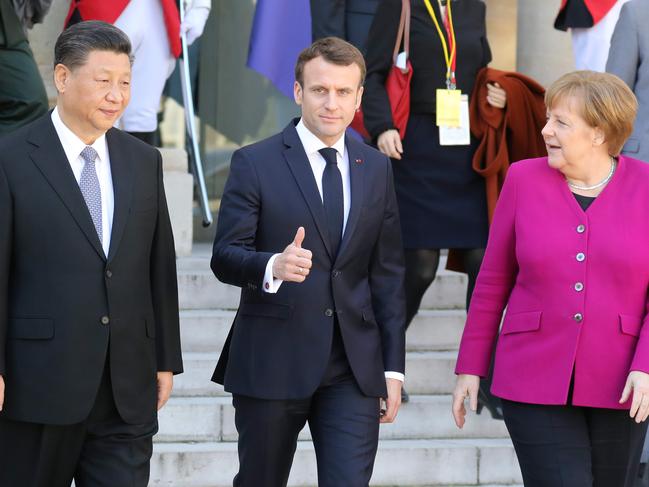 French President Emmanuel Macron (C) gestures next to German Chancellor Angela Merkel (R) and Chinese President Xi Jinping (L) following their meeting at the Elysee Palace in Paris on March 26, 2019. - The leaders of China, France, Germany and the EU were set to meet in Paris on March 26 for "unprecedented" talks on how to improve ties, despite growing jitters over Beijing's massive investments in Europe. (Photo by ludovic MARIN / AFP)