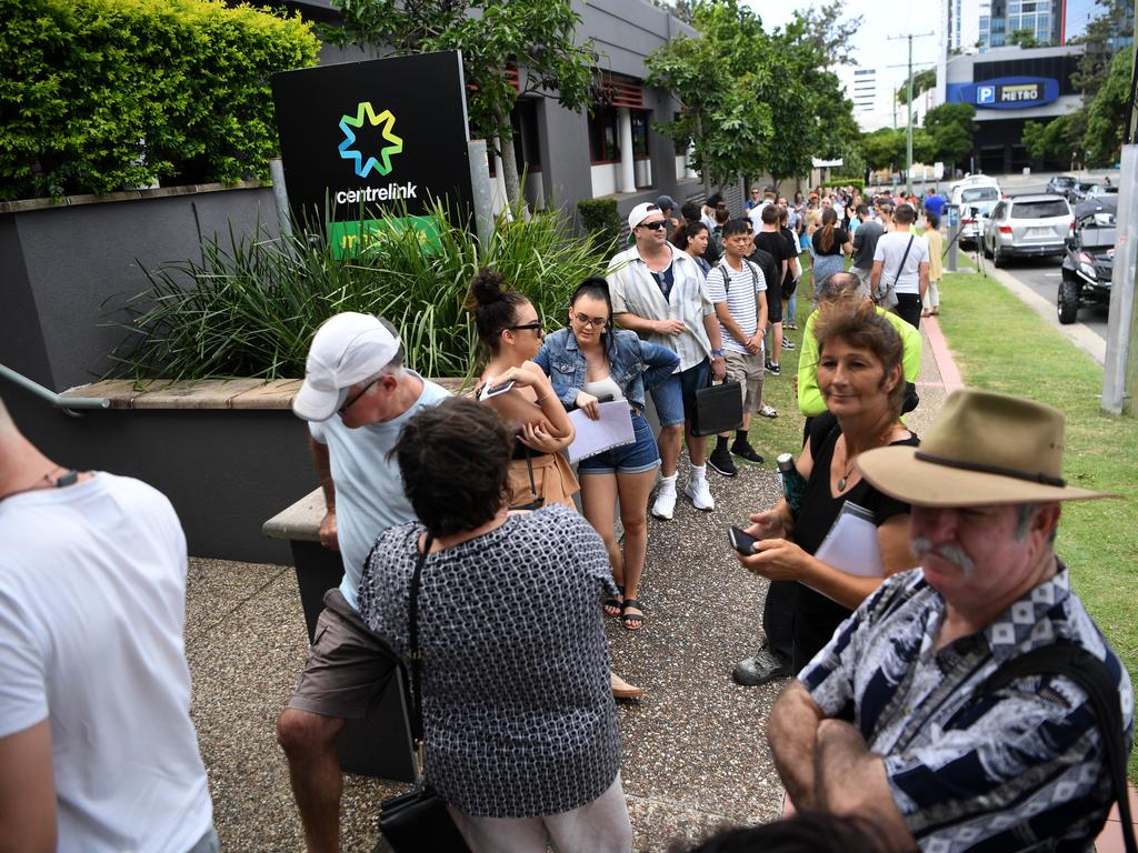 People are seen queueing outside the Centrelink office in Southport on the Gold Coast on Monday. (AAP Image/Dan Peled)