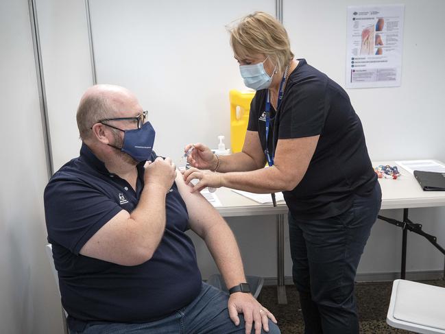 Acting State Health Commander Dale Webster receives a flu vaccination from Vaccination Program Nursing Director  Nikki Lane at PW1. Picture: Chris Kidd