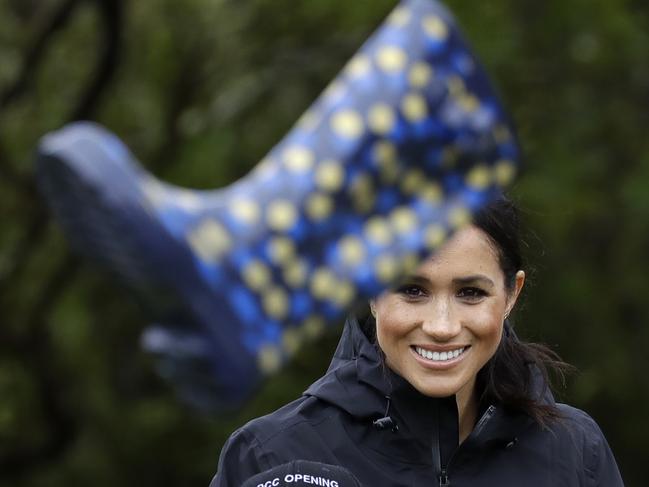 Meghan, Duchess of Sussex reacts with children from the Trees in Survival group in a 'gumboot-throwing' contest following a ceremony to dedicate a 20-hectare area of native bush to the Queen's Commonwealth Canopy in Auckland, New Zealand, Tuesday, Oct. 30, 2018. Prince Harry and his wife Meghan are on day 15 of their 16-day tour of Australia and the South Pacific. (AP Photo/Kirsty Wigglesworth)