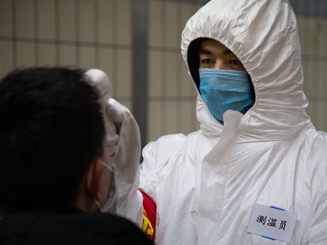 A health worker checks the temperature of a man in Beijing back in January. Picture: Getty