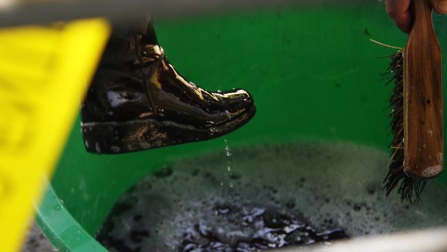 A woman disinfects her boots.