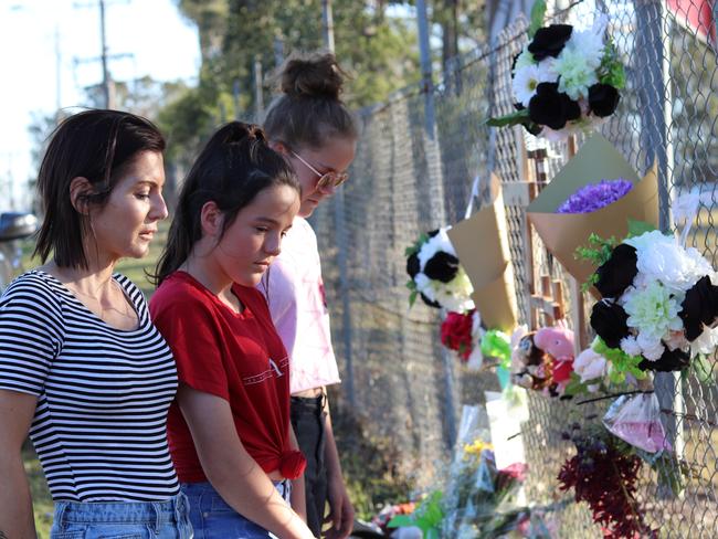 Glenmore Park mum Kristie Burke (striped shirt) and her two daughters Chloe,14, and Hayley,12, lay flowers to show "people care". Picture: Danielle Jarvis