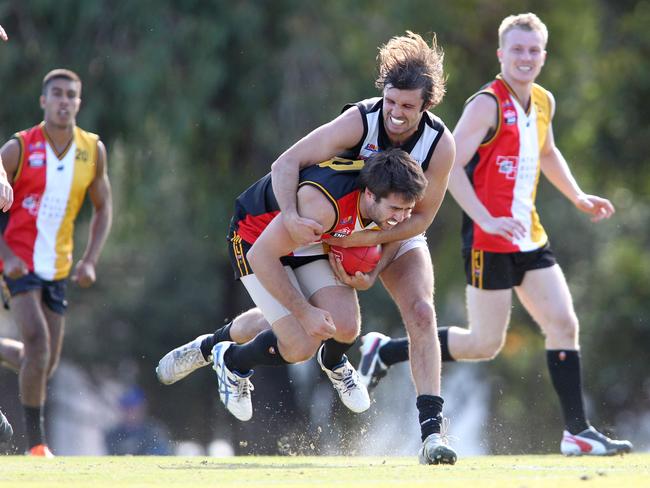 Luke Stanton, of the Goodwood Saints, is tackled by Alex Quin, of Adelaide University.