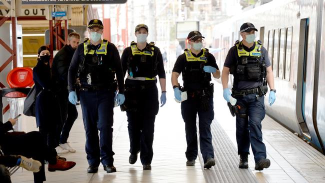 Police and PSOs enforcing mask wearing at Flinders Street Station. Picture: Andrew Henshaw