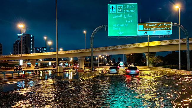 Motorists drive along a flooded street following heavy rains. Picture: Giuseppe Cacace/AFP