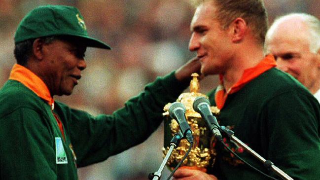 South African President Nelson Mandela hands captain Francois Pienaar the trophy after the Springboks won the 1995 final.