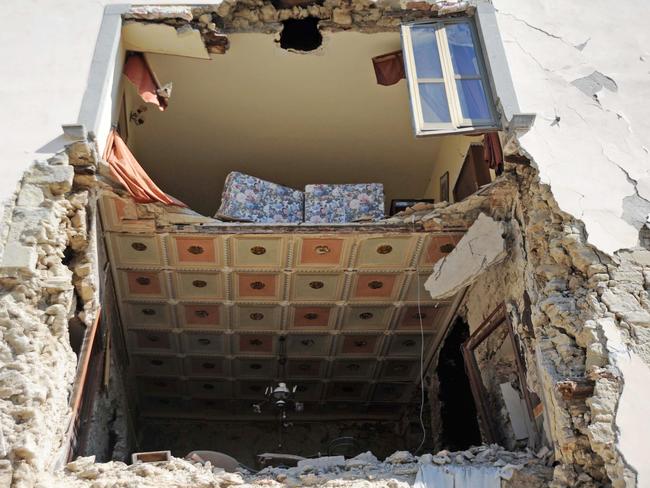 A house is devastated while a living room inside is revealed to the street. Picture: AFP PHOTO / MARCO ZEPPETELLA