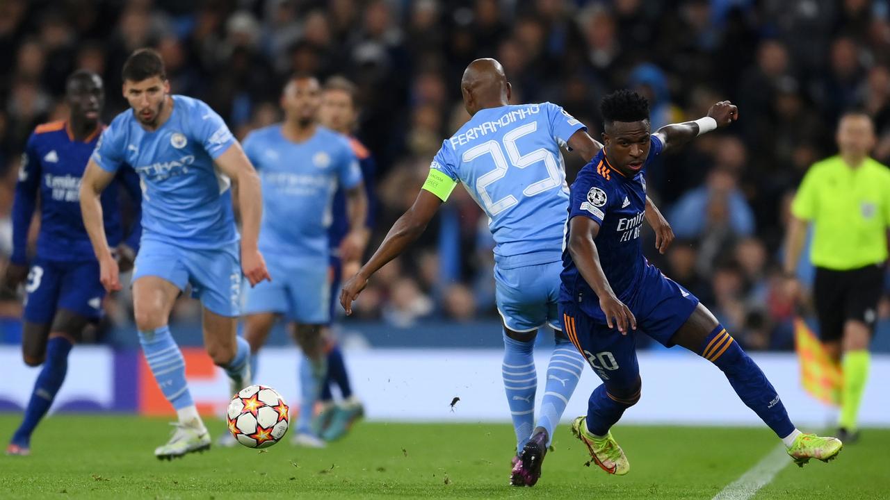 MANCHESTER, ENGLAND - APRIL 26: Vinicius Junior of Real Madrid runs ahead of Fernandinho of Manchester City leading to a goal during the UEFA Champions League Semi Final Leg One match between Manchester City and Real Madrid at Etihad Stadium on April 26, 2022 in Manchester, England. (Photo by David Ramos/Getty Images)