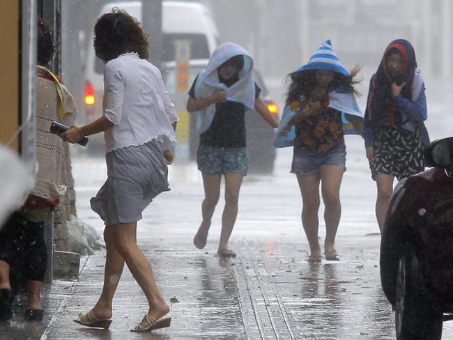 Women battle the strong winds and rain in Naha, Okinawa, southern Japan. Picture: AP Photo/Kyodo News