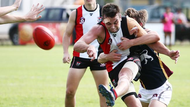 Action from the AFL Cairns match between the Cairns Saints and the Cairns City Lions, held at Griffiths Park, Manunda. Saints' Mark Horne manages to get a kick away. PICTURE: BRENDAN RADKE