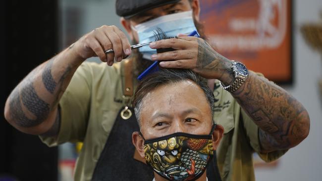 Barber Luis Lopez wears a face mask while cutting Alexander Chin’s hair in Orange County Barbers Parlor in Huntington Beach, California. Picture: AP