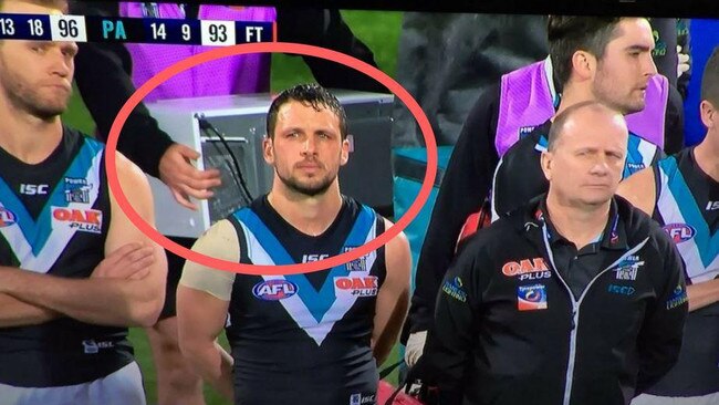 Port Adelaide staff carrying a microwave across the Adelaide Oval.