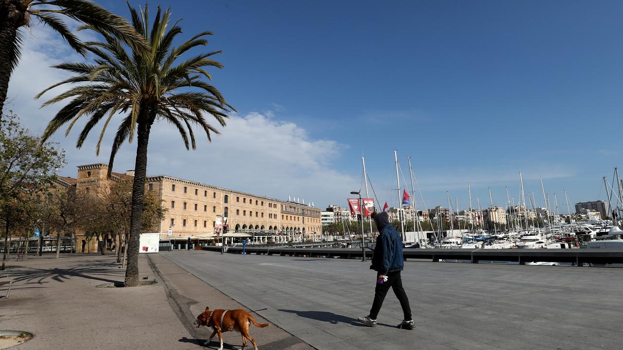 A man walks his dog at Port Vell yesterday in Barcelona. Picture: Sandra Montanez/Getty