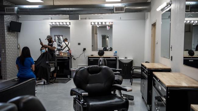 Michael Davis cuts Hayden Lanbrano's hair at the newly reopened Headlines Barbershop in Odessa. Picture: Cengiz Yar