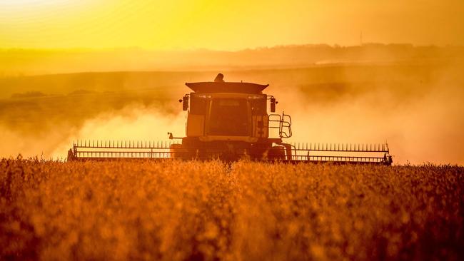 Acombine harvester crops in a field. Picture: Silvio Avila/AFP