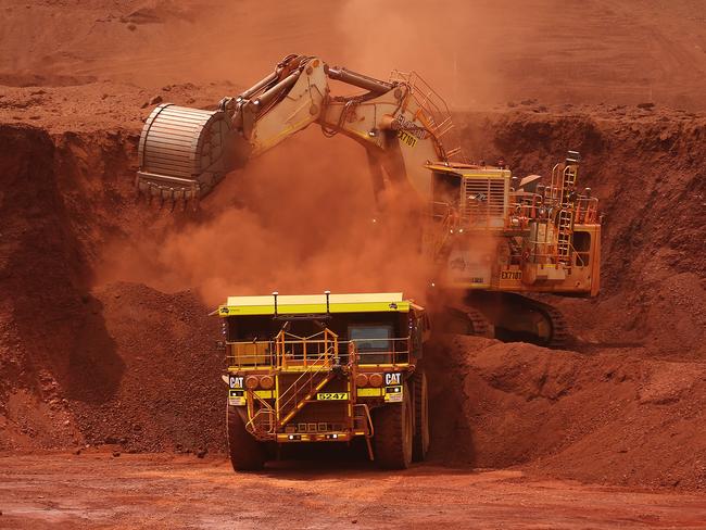 An excavator loads ore into an autonomous dump truck at Fortescue Metals Group Ltd.'s Solomon Hub mining operations in the Pilbara region, Australia. Photographer: Brendon Thorne/Bloomberg via Getty Images