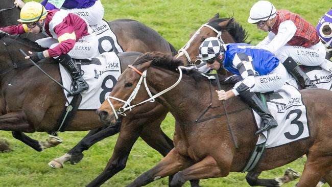 Hugh Bowman (black and white checks) surging to victory on Mugatoo. Picture: Getty