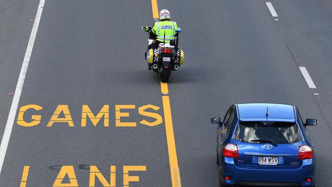 A police officer patrols near a designated Commonwealth Games Lane on the Gold Coast. (AAP Image/Dave Hunt)