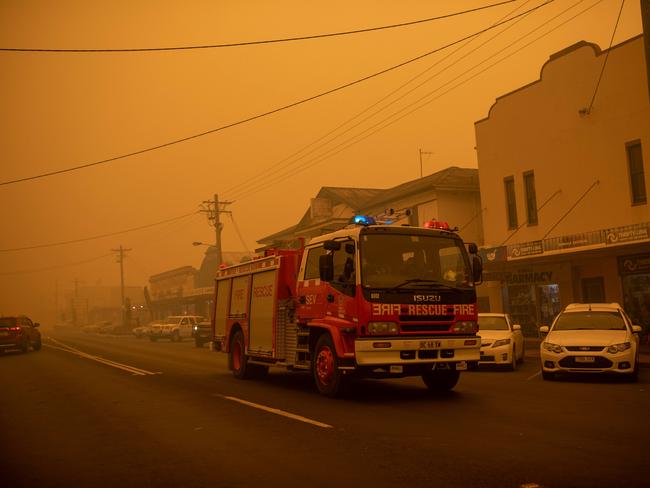 A fire truck moves up the main street of the New South Wales town of Bombala which is shrouded in smoke from nearby bushfires on December 31, 2019. - Thousands of holidaymakers and locals were forced to flee to beaches in fire-ravaged southeast Australia on December 31, as blazes ripped through popular tourist areas leaving no escape by land. Picture: Davey/AFP