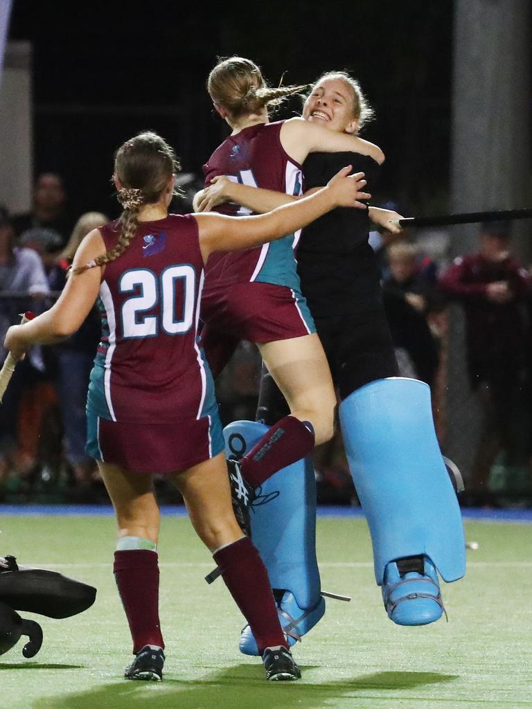 Brothers players rush in hug goal keeper Ella McLeod after she stopped a goal attempt by Saints' Talytha Macdonald to win the penalty shootout and the match for her team in the Cairns Hockey Association Under 18A Women's match between the Brothers Fury and the Cairns Saints. PICTURE: BRENDAN RADKE