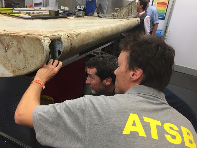 Malaysian and Australian investigators in Canberra examining a piece of aircraft debris found on Pemba Island off the coast of Tanzania. Picture: ATSB/AFP