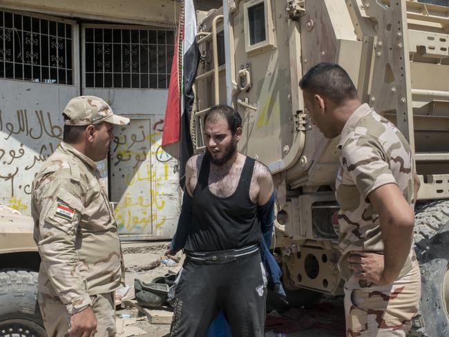 An Iraqi man, believed to be a possible Islamic State militant, is questioned and searched, in Mosul last month. Picture: Martyn Aim/Getty Images