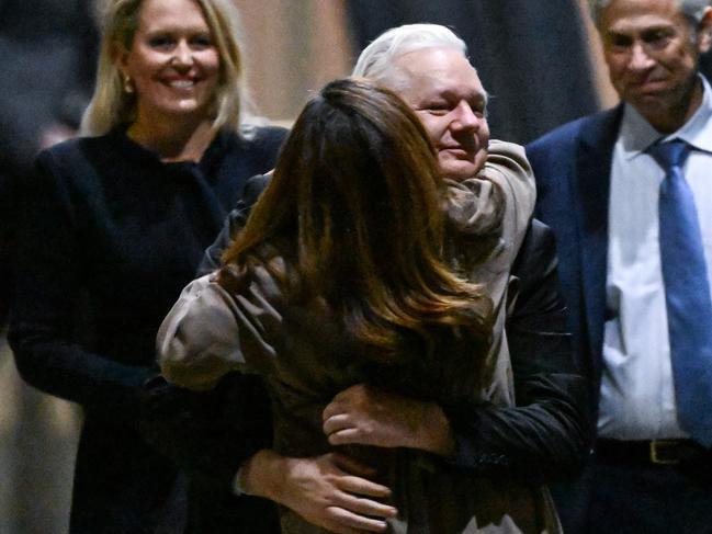 WikiLeaks founder Julian Assange (C) hugs his wife Stella Assange (centre L) after arriving at Canberra Airport in Canberra on June 26, 2024, after he pleaded guilty at a US court in Saipan to a single count of conspiracy to obtain and disseminate US national defence information. WikiLeaks founder Julian Assange returned home to Australia to start life as a free man June 26 after admitting he revealed US defence secrets in a deal that unlocked the door to his London prison cell. (Photo by WILLIAM WEST / AFP)