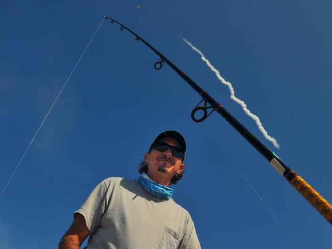 Incredible backdrop ... Tim Faucher baits his hook while fishing at Canaveral National Seashore in as the Falcon 9 SpaceX rocket lifts off.