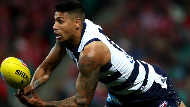 SYDNEY, AUSTRALIA - JULY 28: Tim Kelly of the Cats hand-passes as he is tackled by Zak Jones of the Swans during the round 19 AFL match between the Sydney Swans and the Geelong Cats at Sydney Cricket Ground on July 28, 2019 in Sydney, Australia. (Photo by Cameron Spencer/Getty Images)